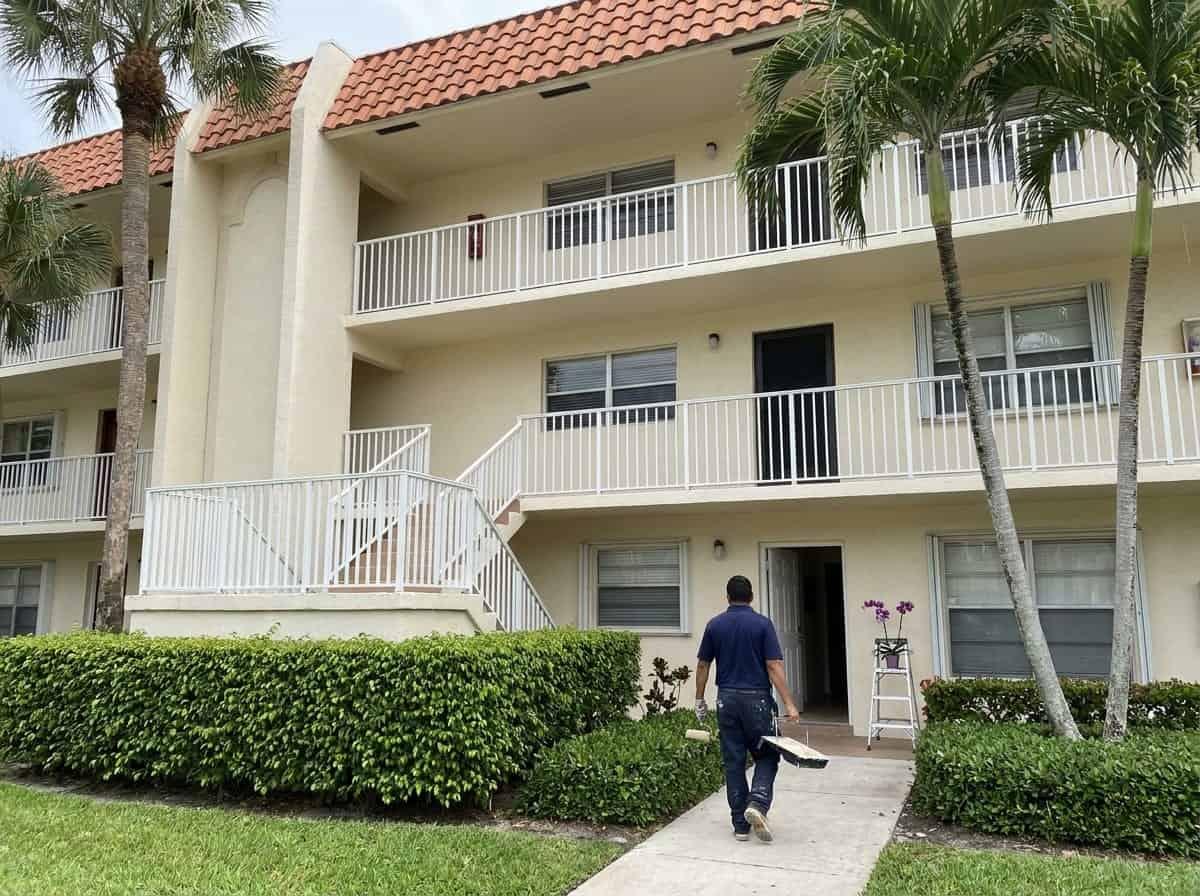 Painting a condominium unit along an open walkway in West Boca Raton, FL