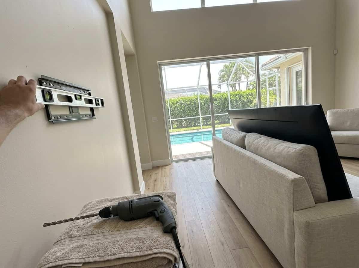 TV wall bracket being mounted on a block wall in Palm Beach County, FL