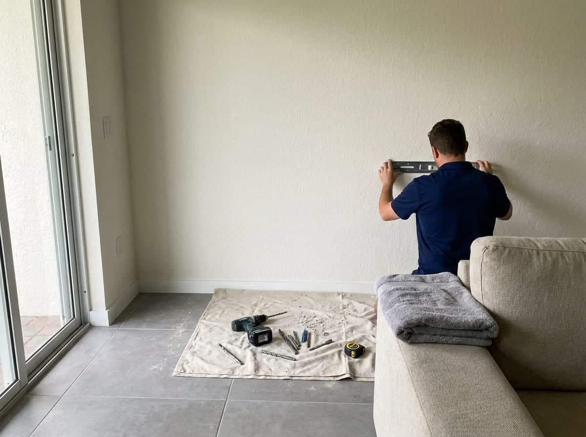 Marking a TV mount on a concrete block wall in a home in Palm Beach County, FL