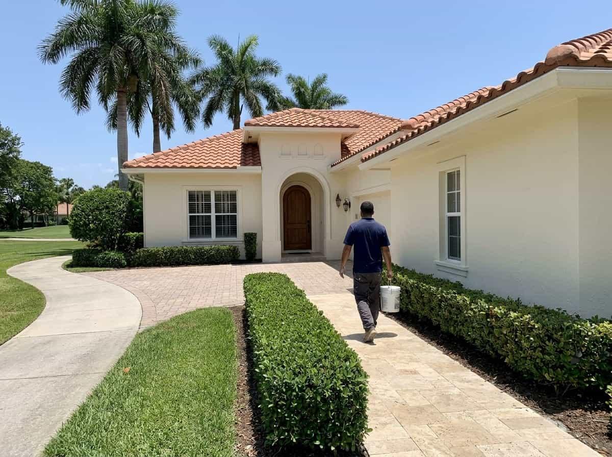 Painter carrying supplies to a golf community villa in Atlantis, FL