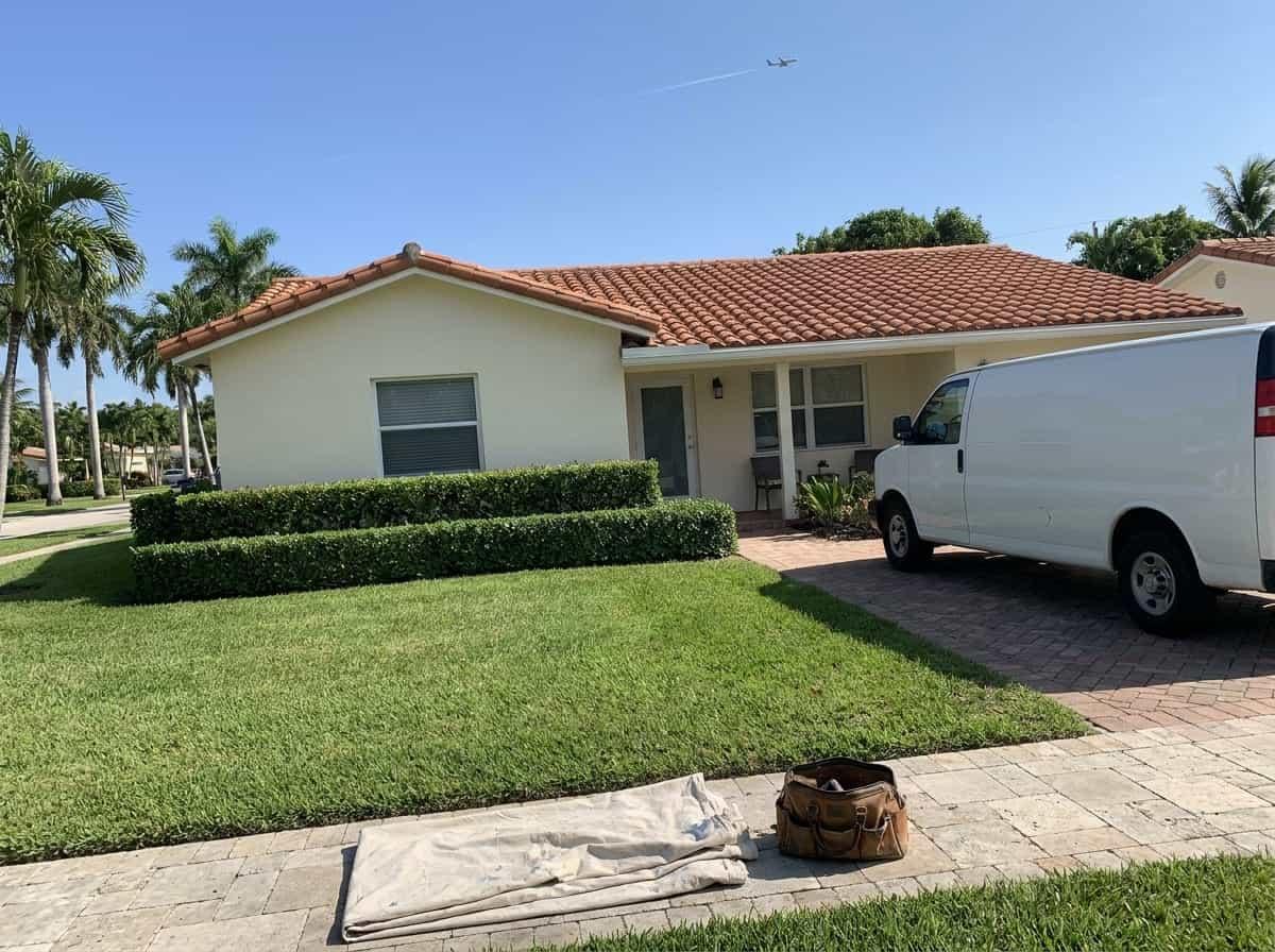 Well-kept house on a palm-lined street with a work van in the driveway in Cloud Lake, FL