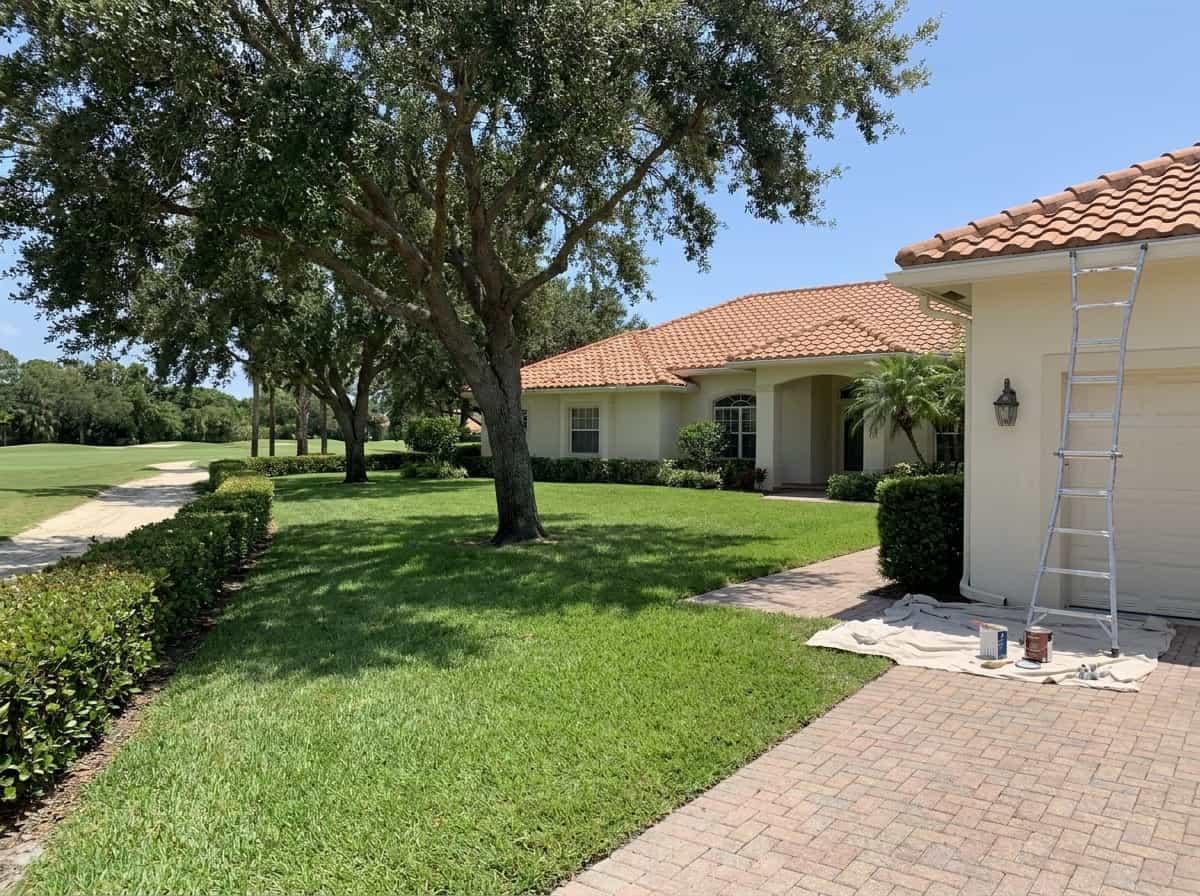 Large stucco house set back from the road beside a fairway in Golf, FL