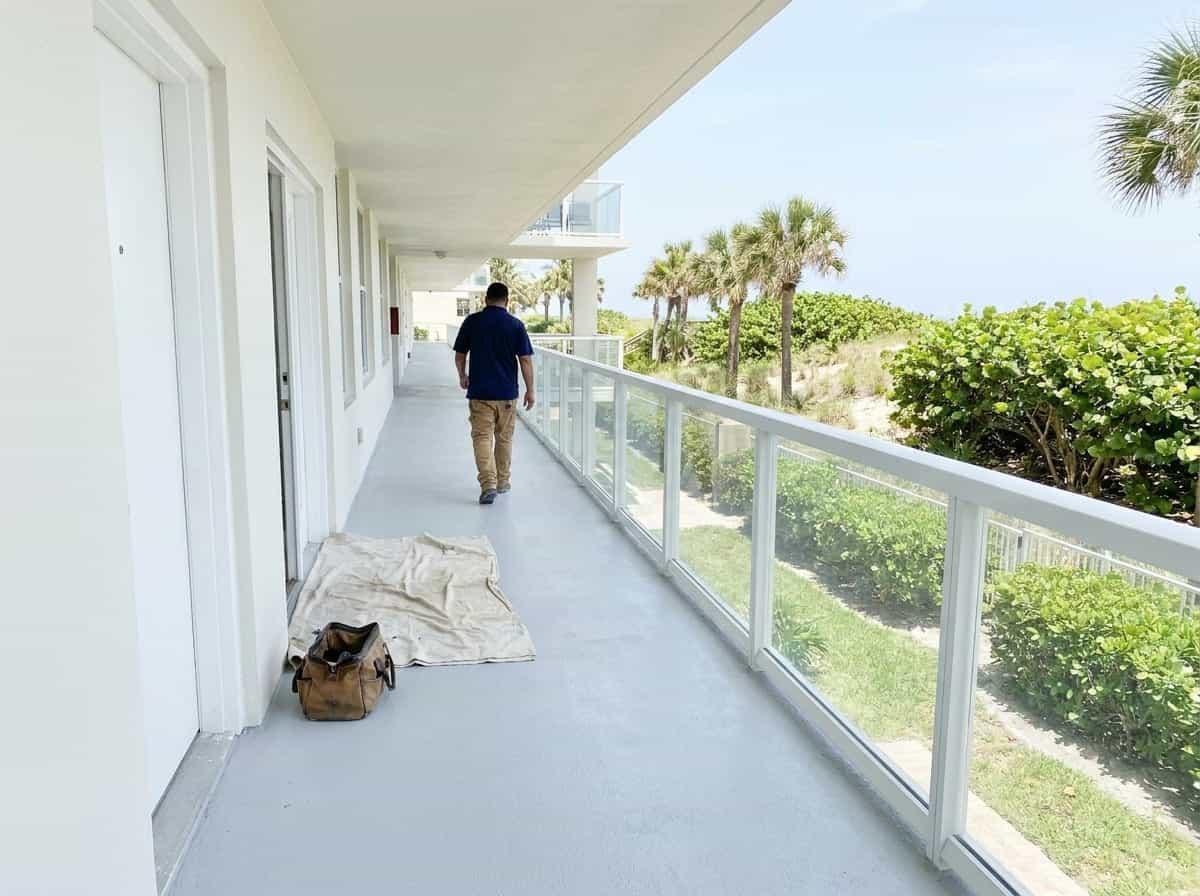 Condo walkway with tools set out beside a unit door in South Palm Beach, FL