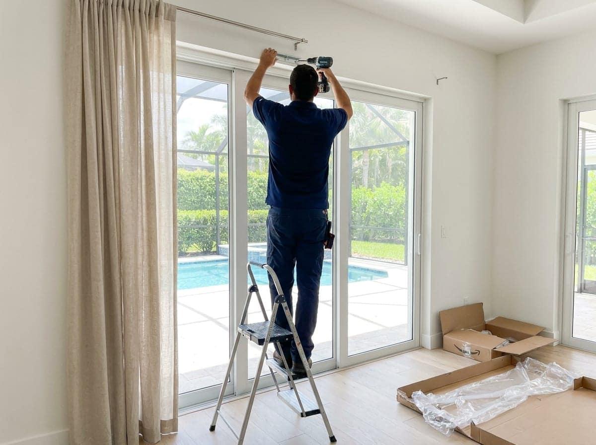 Curtain rod being installed above a sliding door in Palm Beach County, FL
