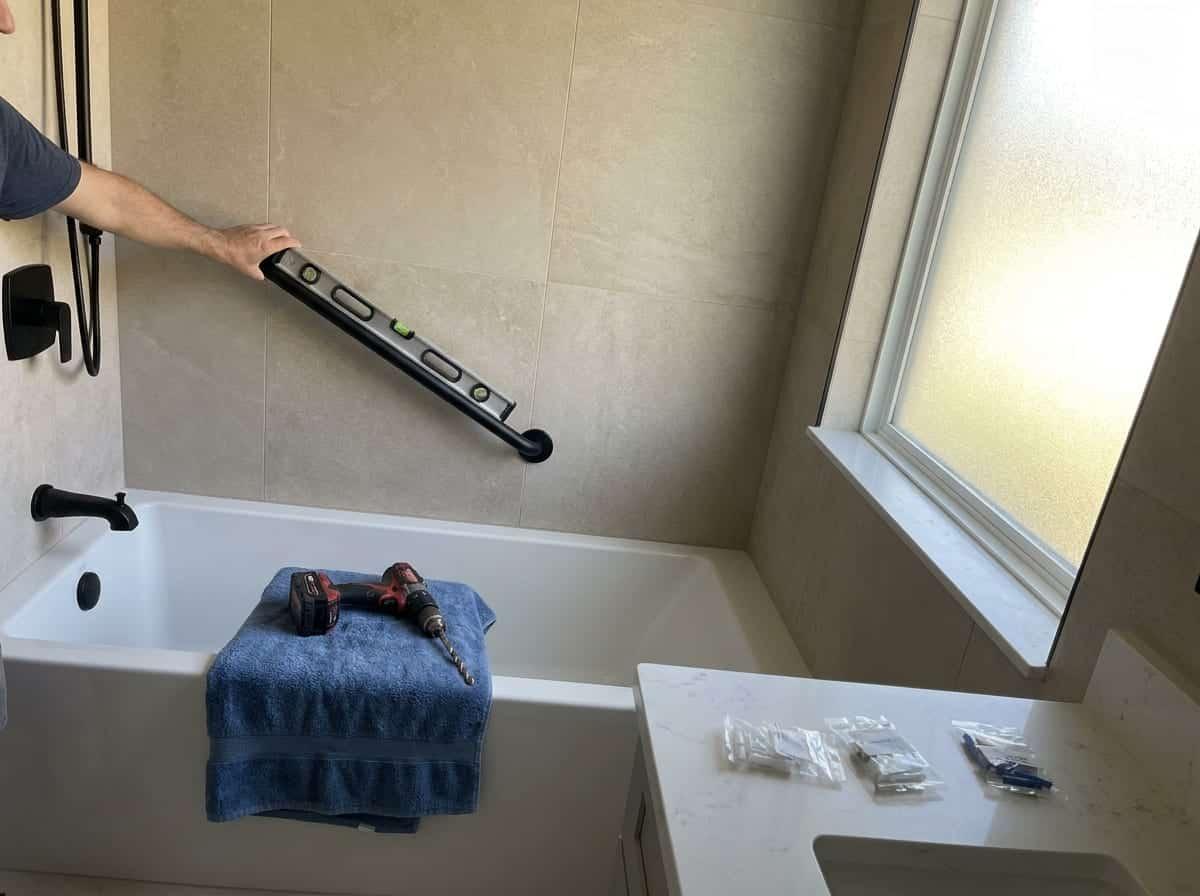 Grab bar being installed beside a tub in a home in Palm Beach County, FL