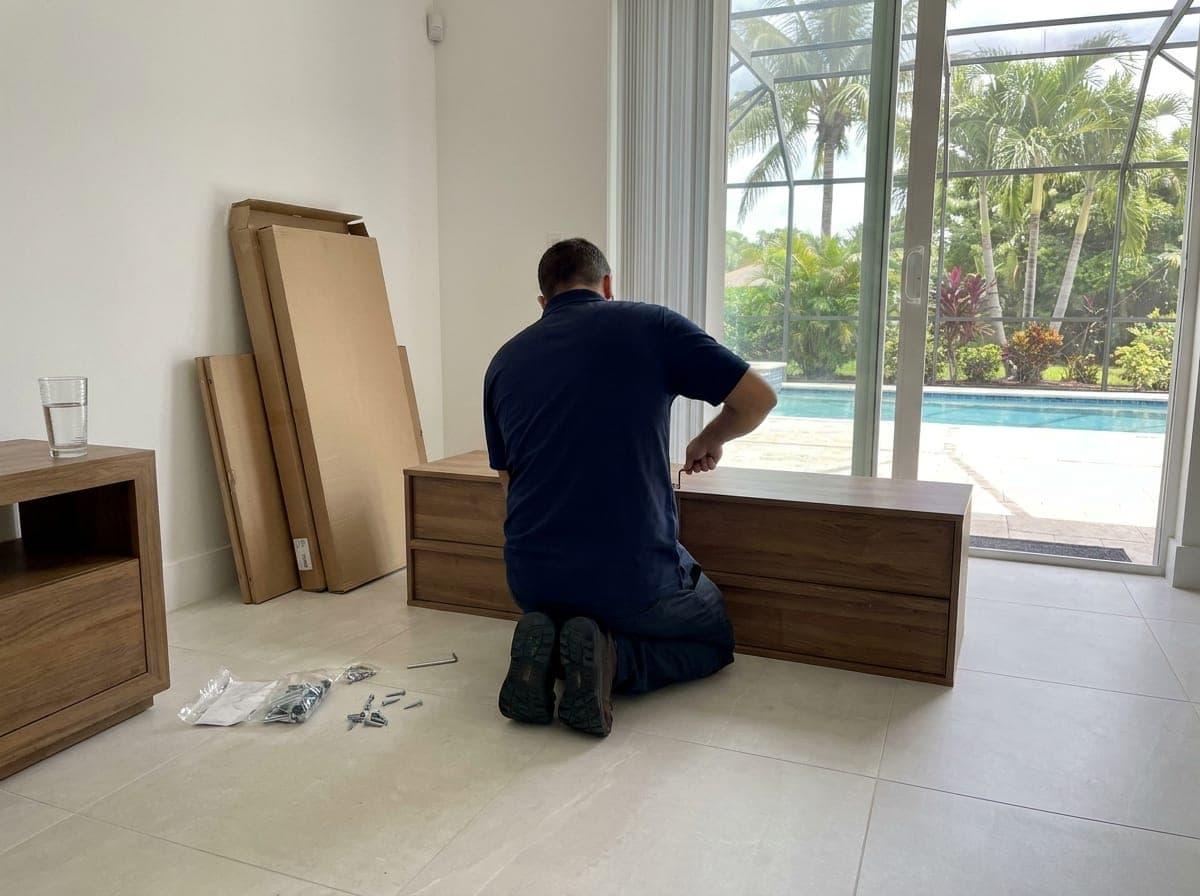 Technician assembling a dresser in a bright living room in Palm Beach County, FL